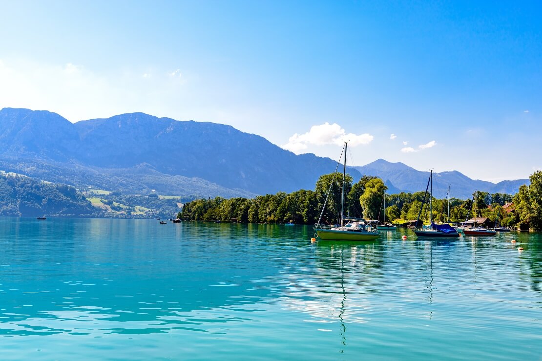 Segelboote auf einem türkisen See im Hintergrund sind die Berge