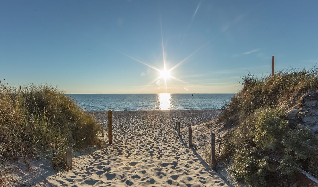 Küste mit Sand bei Sonnenuntergang