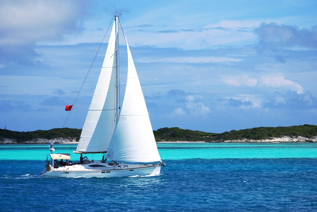 Segelboot schwimmt vor einer Insel bei den Bahamas