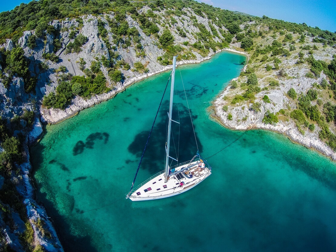 Segelboot in einer Bucht im türkisblauen Wasser in Kroatien