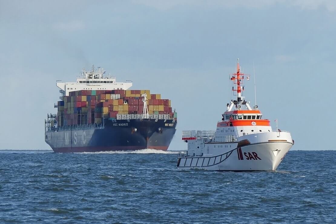 Seenotrettungskreuzer mit Containerfrachter